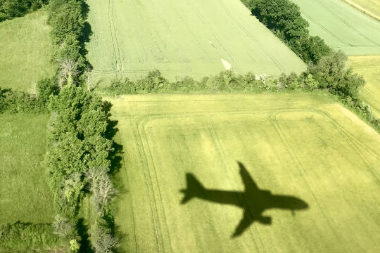 Über den Wolken CO₂-frei sein - Ohne massive Änderungen in der Luftfahrt lassen sich die Klimaschutzziele nicht erreichen. Verbesserungen sind in Sicht, doch noch lange bleibt klimaverträgliches Fliegen eine Utopie. - © iStock / Nicolas Jooris-Ancion (Bildbearbeitung: Rainer Messerklinger)